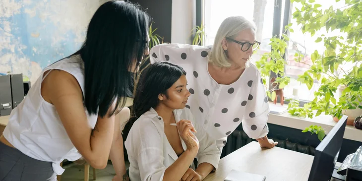 A senior account manager assisting a team member with an online customer query.