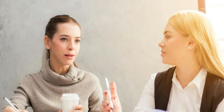A senior product marketing manager discusses marketing strategies with a team member.
