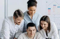 Ein Team arbeitet lächelnd in einem Büro.