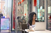 Un trabajador independiente trabajando en su computadora portátil desde un restaurante.