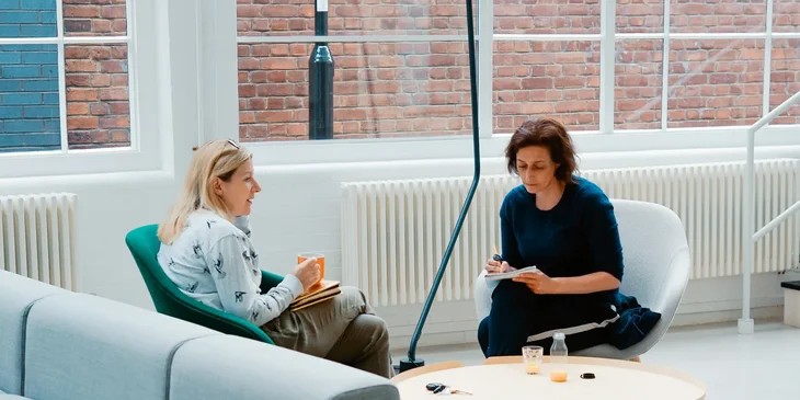 A female solicitor with an orange mug provides legal advice to a client.