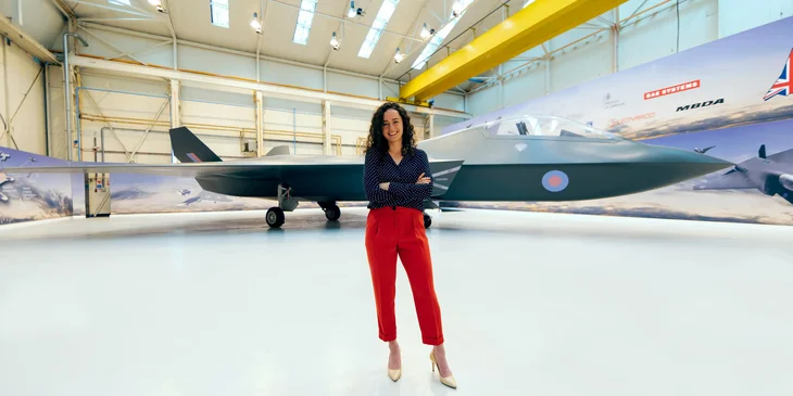 A female engineer standing in hangar.