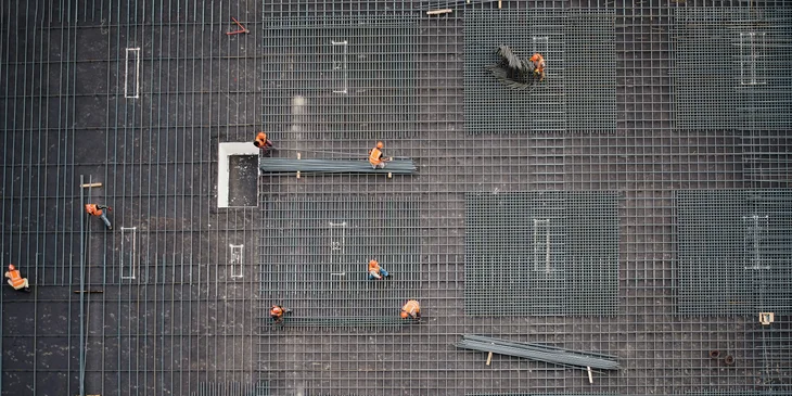 Steel fixers positioning steel bars at a construction site.