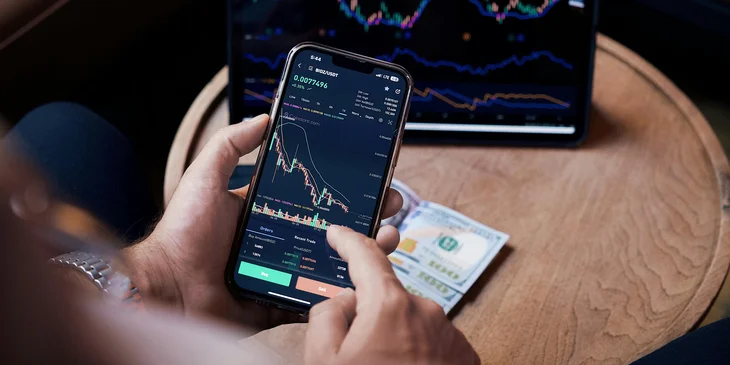 A stockbroker reviewing market fluctuations on his phone.