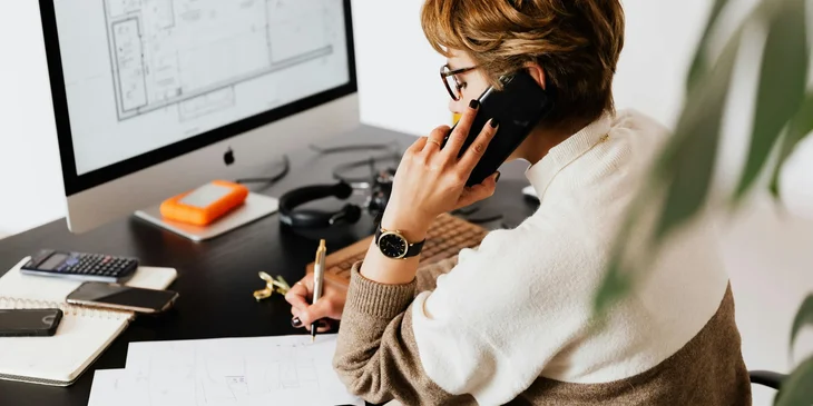 A businesswoman talking on the phone in her office.