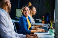 Una mujer de saco azul sonriendo.