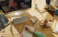 A woman working from home attends an online meeting with her supervisor.