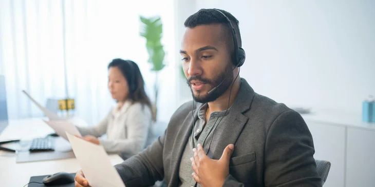 A telesales executive talking to a client over the phone, persuading them to make a purchase.