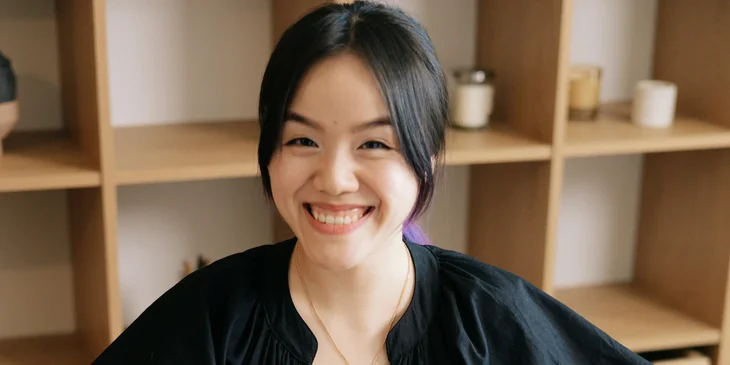 A woman in a black top smiling.