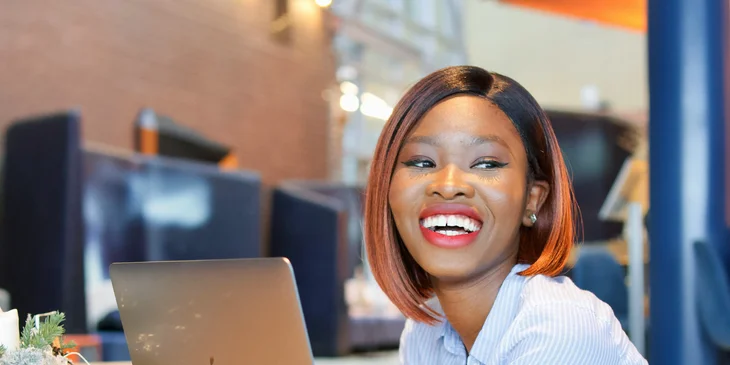 A person laughing at her desk.