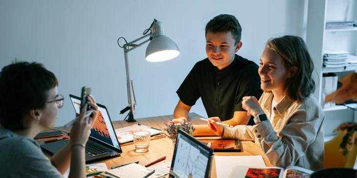 A team discusses the project at the desk.