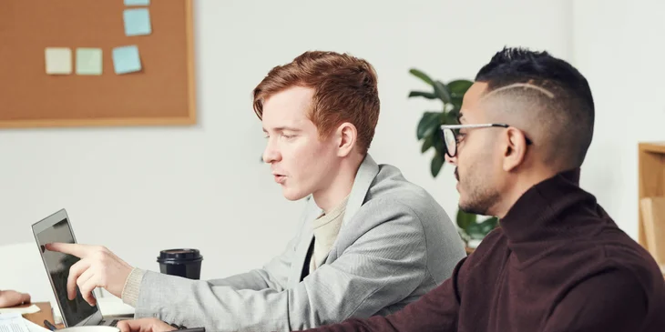 Coworkers discuss their project using a computer.