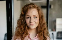 Ein Trainee steht in einem Büro und lächelt.