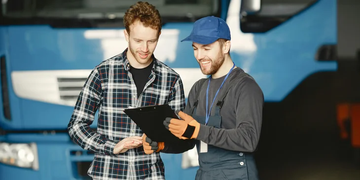 A man in blue cap showing a black folder to his coworker.