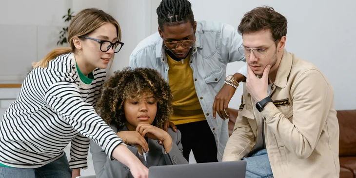 A group of people planning while looking at a laptop.