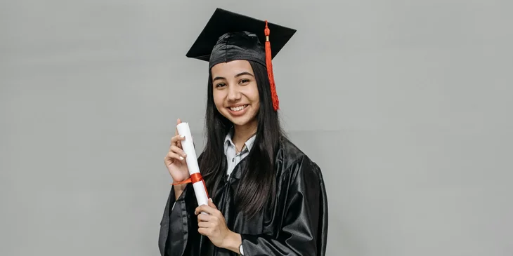 A woman holding a diploma.