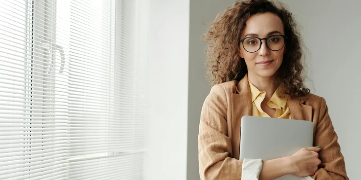 A woman holding a laptop.