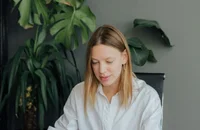 Freiberufler sitzt an einem Schreibtisch und arbeitet an seinem Laptop.