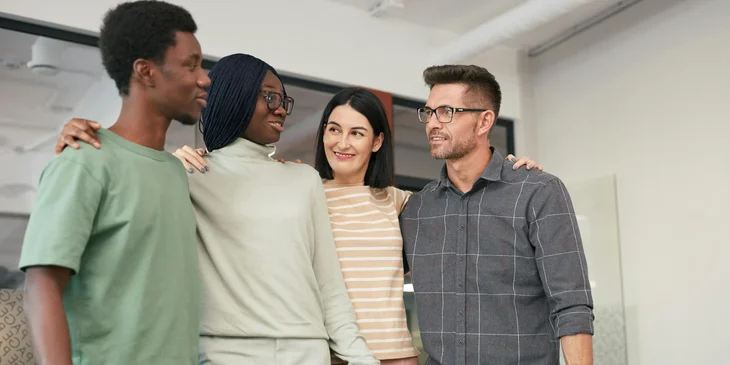 Employees from diverse backgrounds work together in an office.