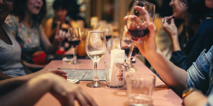 A group of people tasting wine at an event.