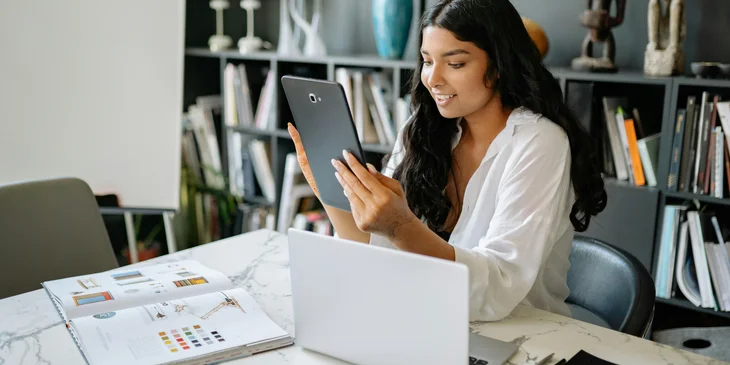 A woman working on a tablet.