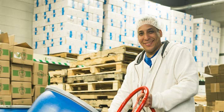 A warehouse helper moving a barrel