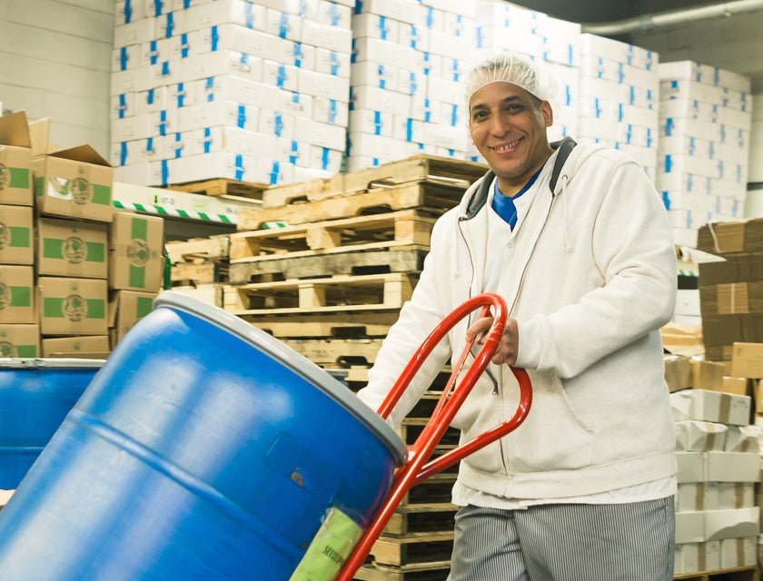 A warehouse helper moving a barrel