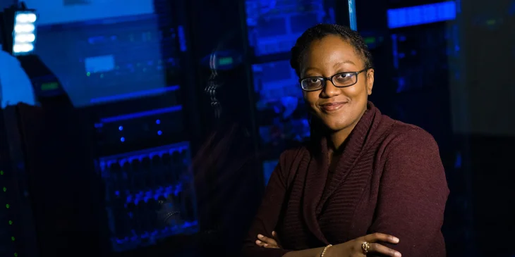 A female software engineer wearing a brown cardigan.