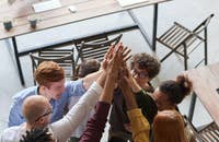 Un círculo de compañeros de trabajo felicitándose.