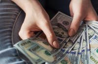 Un par de manos sosteniendo un pago por mérito.