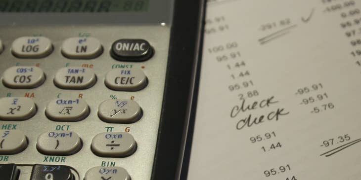 Calculator, pen, and ledger used by forensic accountants.