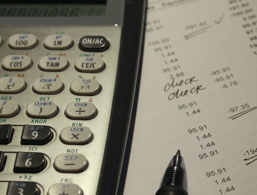 Calculator, pen, and ledger used by forensic accountants.
