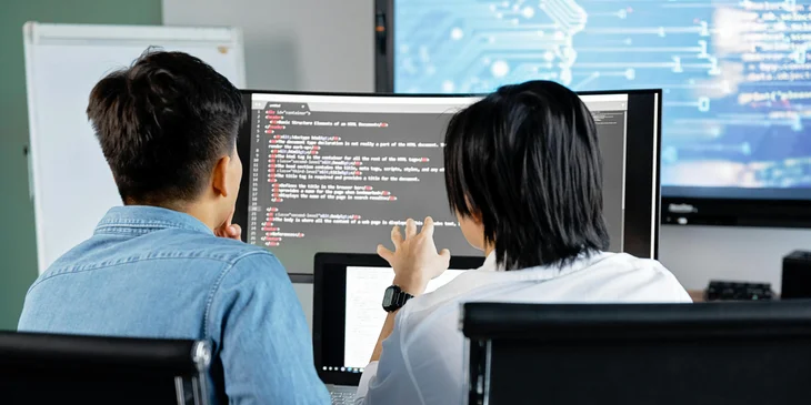 Two Windows administrators installing new software on a computer.