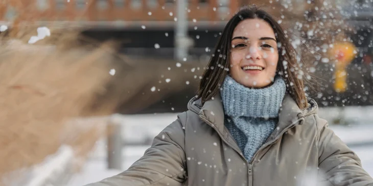 A woman delighting in the snowfall.