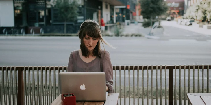 A writer busy working on a short story for her weekly content while outdoors.