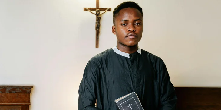 A pastor holding a black book.