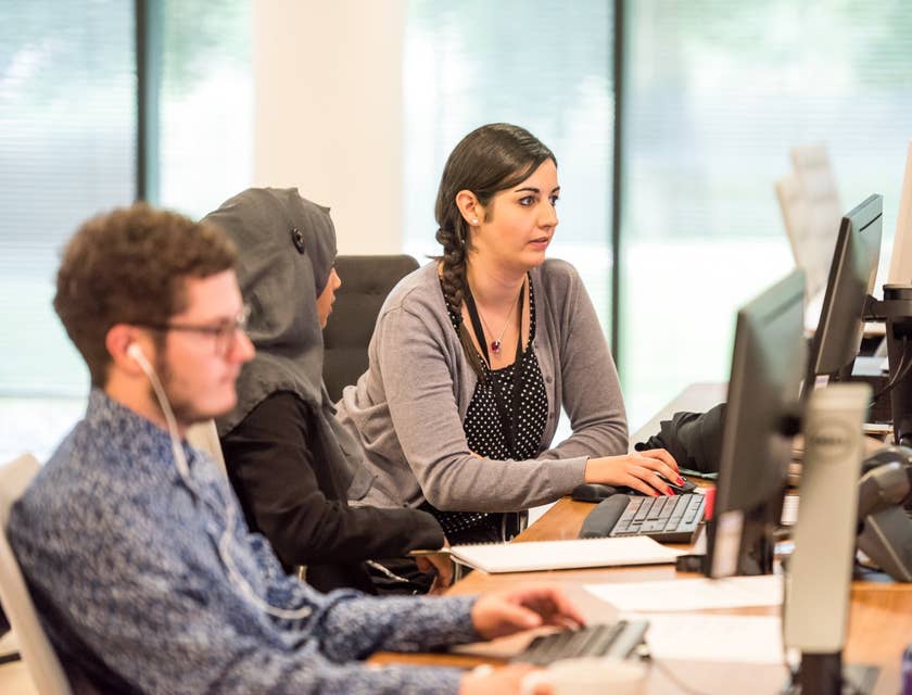Bilingual Customer Service Representatives lined up along the desk working on their respective computers