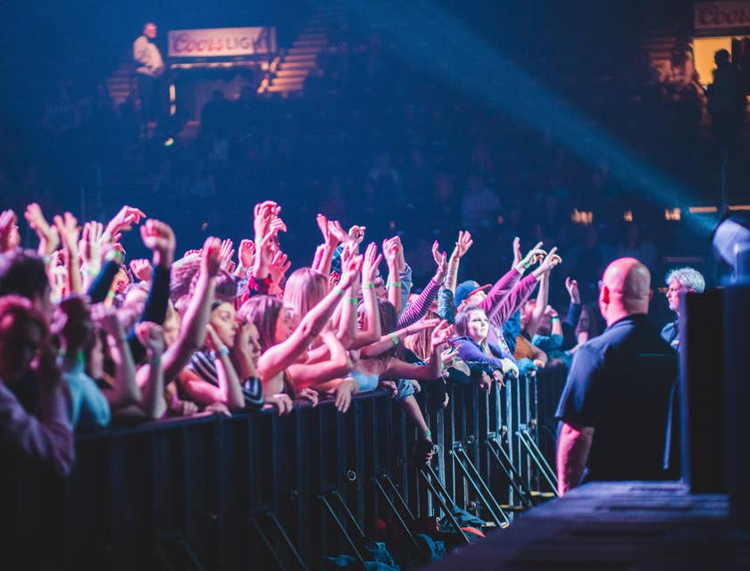 Bouncers stationed in front of the stage facing the crowd during an ongoing performance