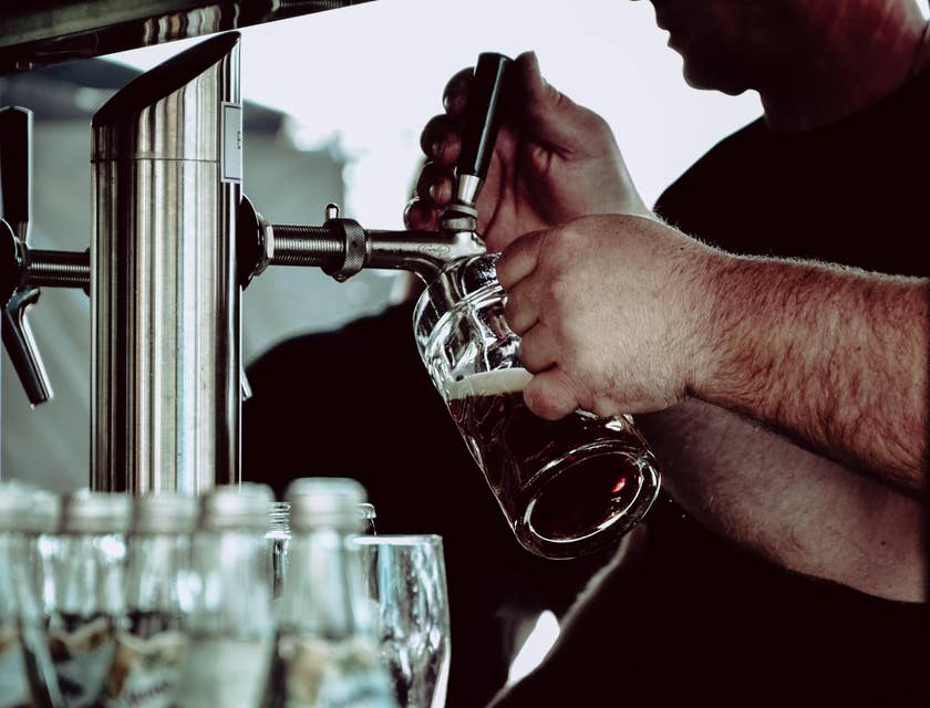 A Brewmaster pouring crafted beer into a glass for taste testing to ensure beer is in perfect quality.
