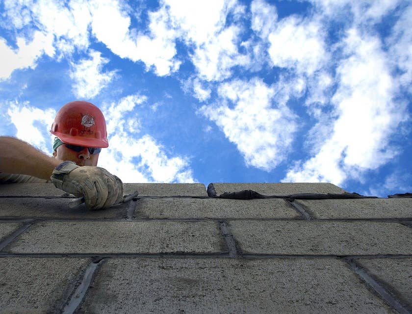 Bricklayer carefully laying bricks for a commercial building.
