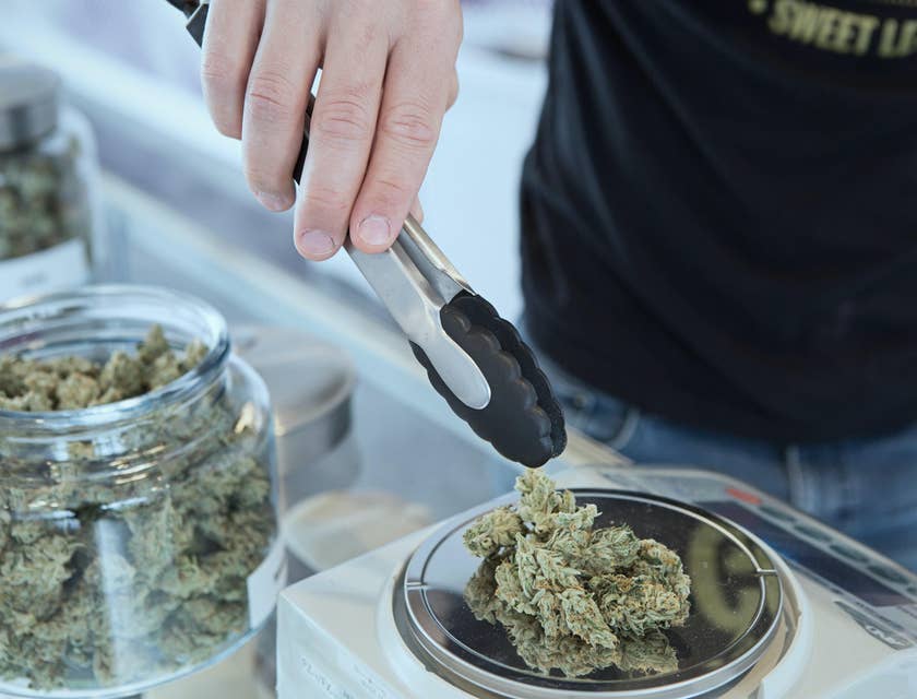 Budtender weighing customers order before packing