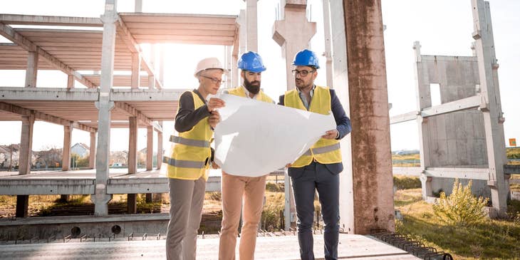Building surveyor meets with the engineer and architect to discuss project ideas.