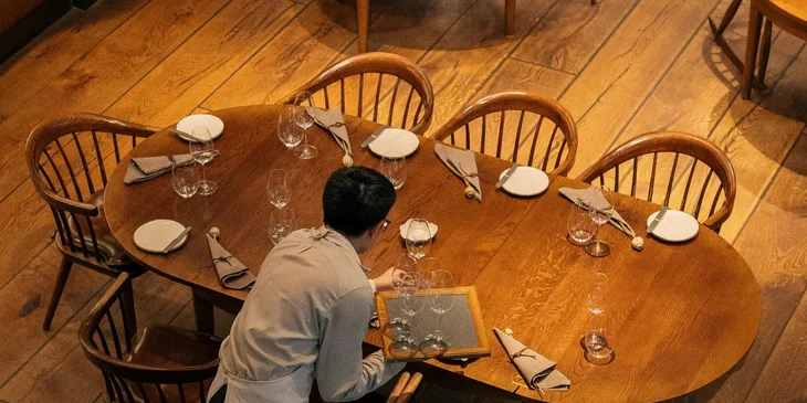 The busboy prepares the table before another customer arrives.