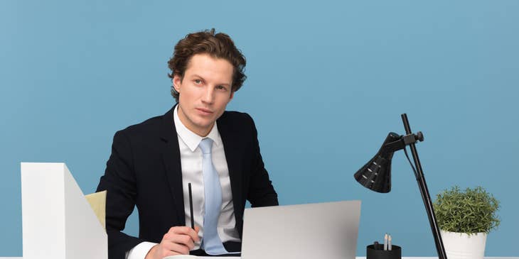 Business Operations Manager sitting at his workstation while looking on the team operating outside his office