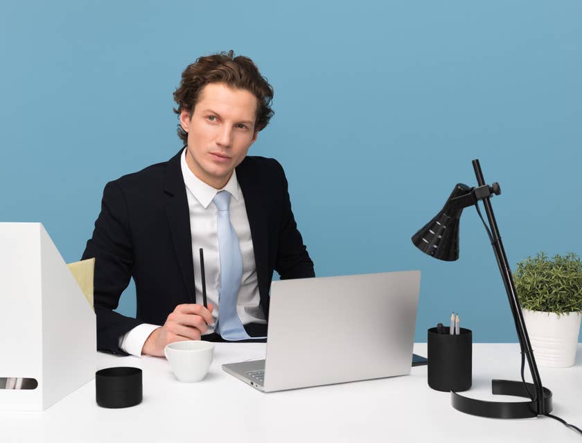 Business Operations Manager sitting at his workstation while looking on the team operating outside his office