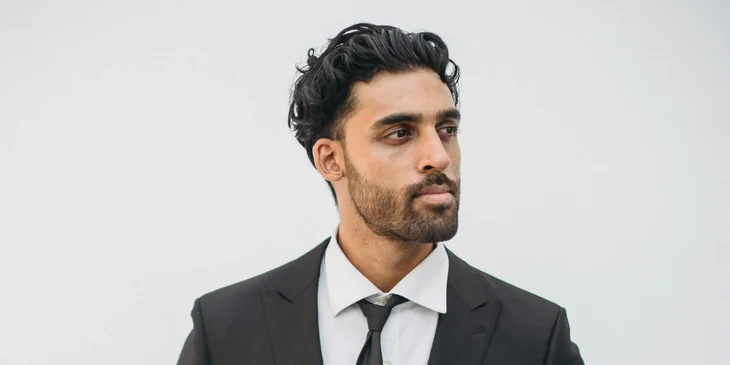 A butler wearing a suit and tie.