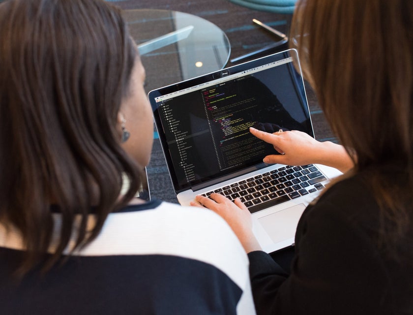 C Developer showing the components of the code while her colleague looks on her screen