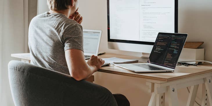 C# Developer sitting in front of his workstation and checking the details of the code he is working on