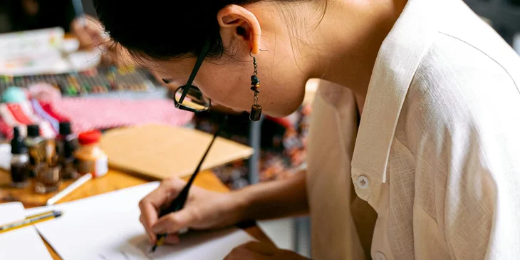 A calligrapher writing on paper.
