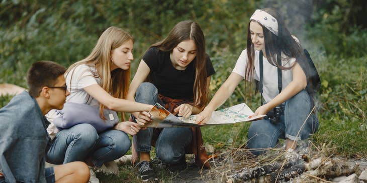 Camp Counselor teaching a group of campers how to read a map.